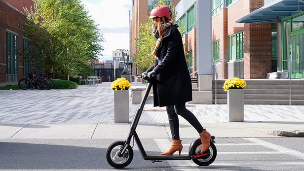 Girl wearing a helment using an e-scooter